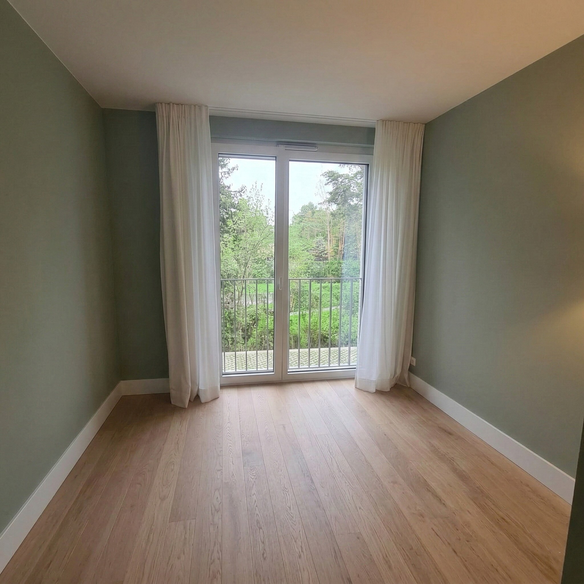 Chambre avec baie vitrée et vue sur la verdure